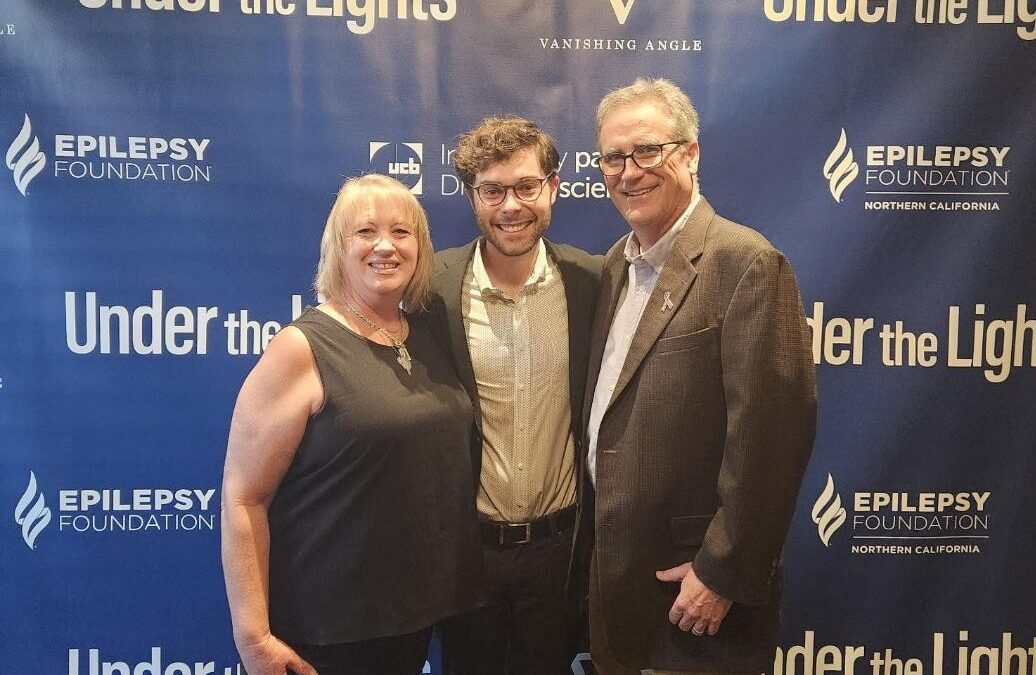 3 people in front of Under the Lights banner