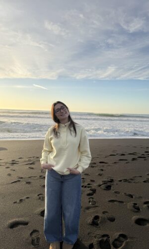Young woman standing with white sweatshirt on the beach